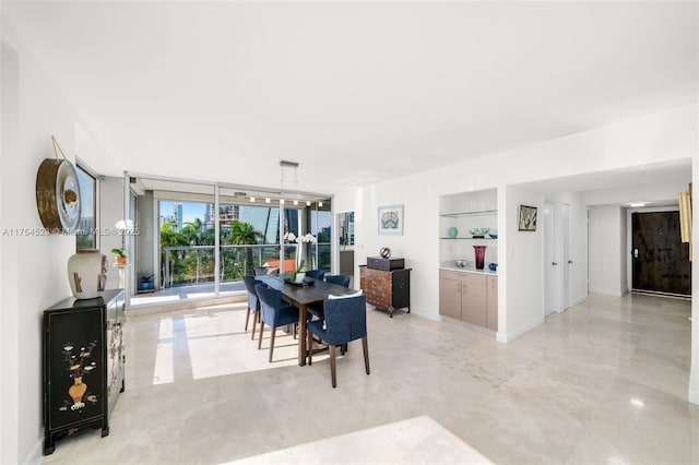 dining area featuring baseboards, a wall of windows, and built in features