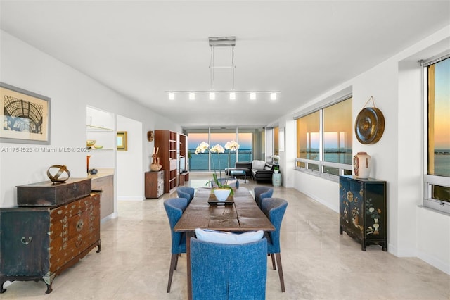 dining space with an inviting chandelier, baseboards, and track lighting