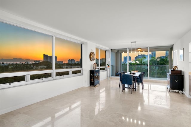 dining space with baseboards and a wall of windows