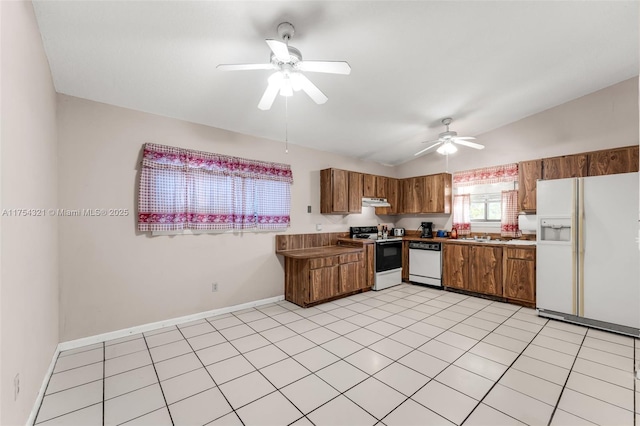 kitchen with lofted ceiling, under cabinet range hood, white appliances, and brown cabinets