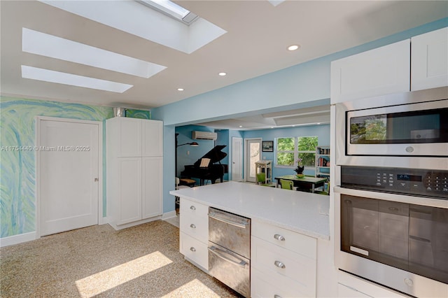 kitchen featuring wallpapered walls, a wall unit AC, stainless steel appliances, white cabinetry, and recessed lighting