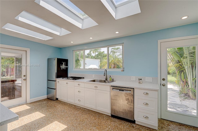 kitchen with recessed lighting, light countertops, appliances with stainless steel finishes, white cabinets, and a sink