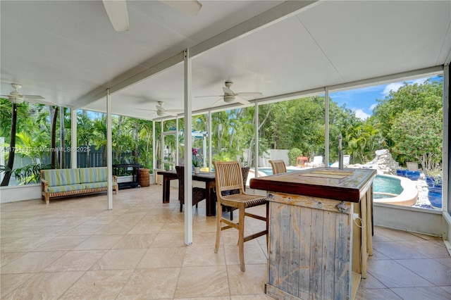 sunroom / solarium featuring a ceiling fan and a wealth of natural light