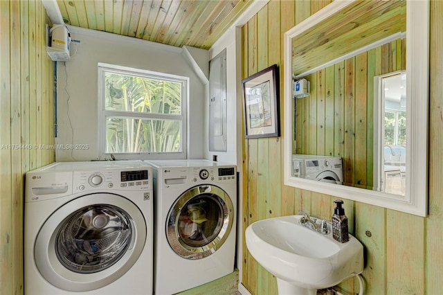 laundry area featuring laundry area, wood ceiling, washer and clothes dryer, and a sink