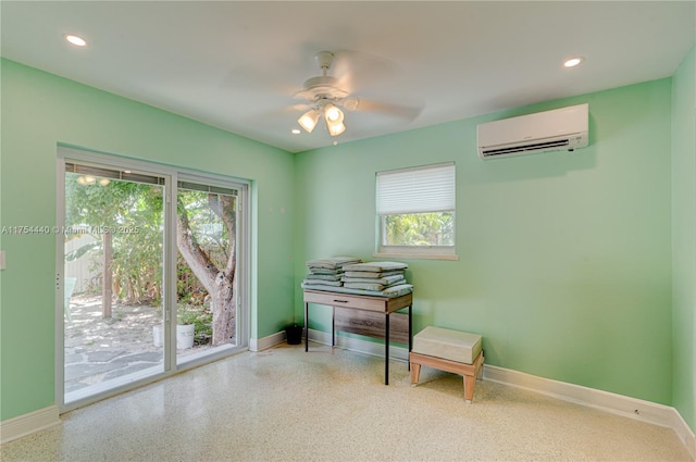 sitting room with recessed lighting, speckled floor, baseboards, and a wall mounted AC