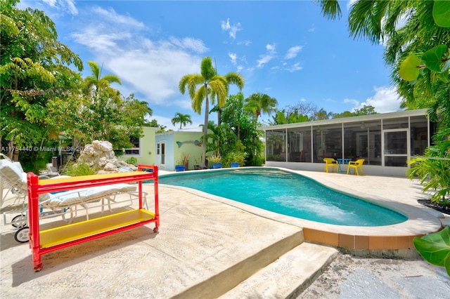 outdoor pool featuring a patio and a sunroom