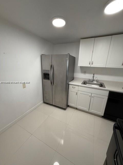 kitchen with a sink, white cabinets, black dishwasher, light countertops, and stainless steel refrigerator with ice dispenser