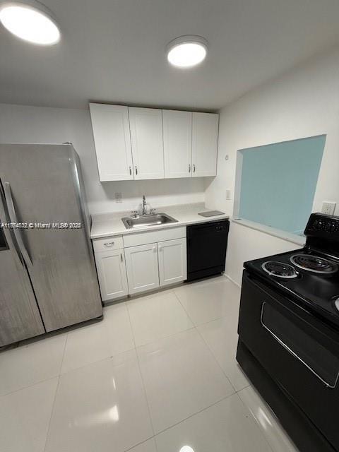 kitchen with black appliances, a sink, light countertops, and white cabinets