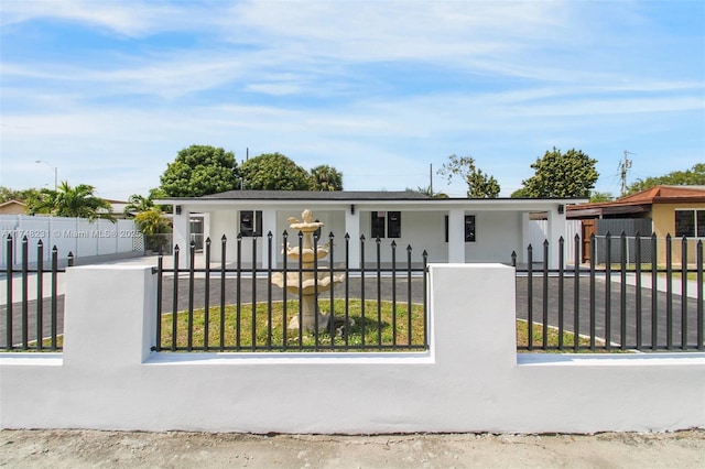 view of front of house with a fenced front yard and a gate