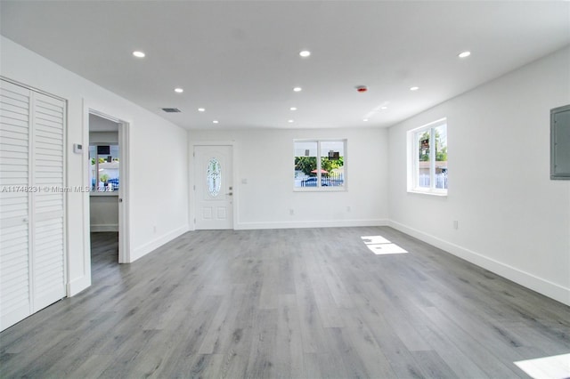 unfurnished living room featuring recessed lighting, baseboards, and wood finished floors