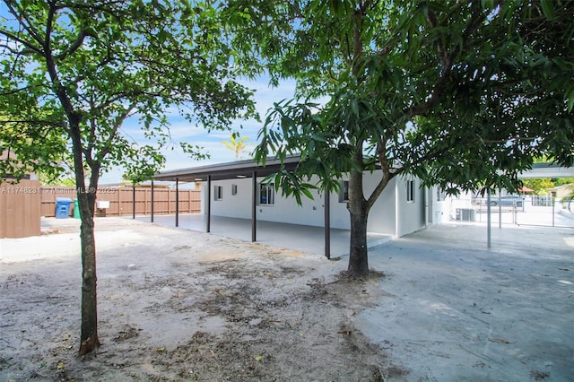 exterior space featuring a patio area, fence, and stucco siding