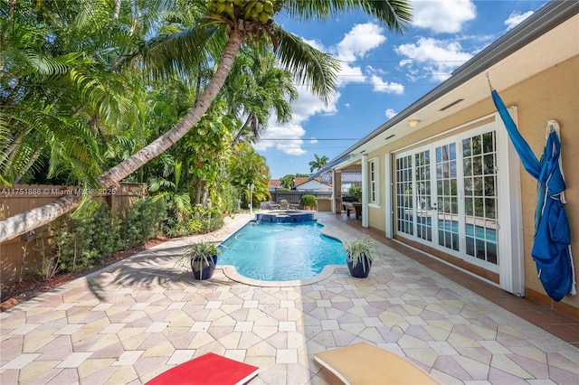 view of pool featuring a pool with connected hot tub, a fenced backyard, and a patio