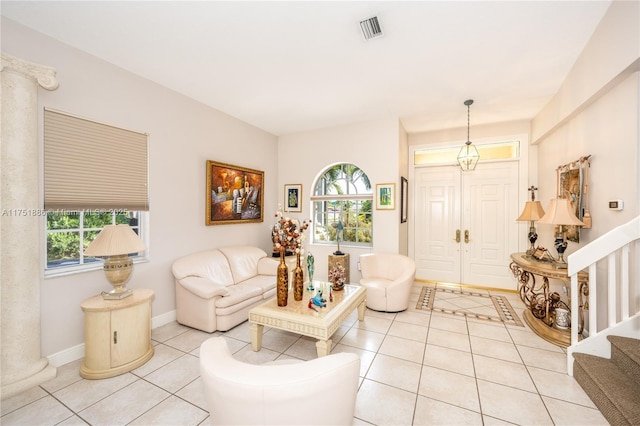 living room featuring a healthy amount of sunlight, light tile patterned floors, stairs, and baseboards