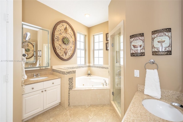 bathroom featuring a shower stall, a tub with jets, two vanities, and a sink