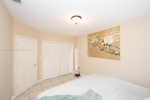 bedroom featuring baseboards, visible vents, a closet, and tile patterned floors