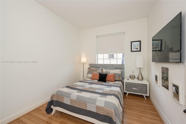 bedroom featuring wood finished floors and baseboards