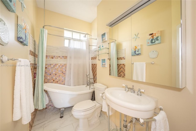 bathroom with a shower with curtain, a freestanding tub, a sink, and toilet