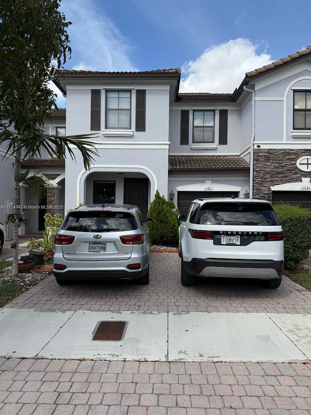 view of front facade with decorative driveway and stucco siding