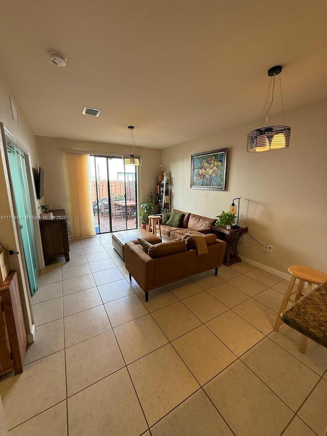 living area featuring light tile patterned floors, baseboards, and visible vents