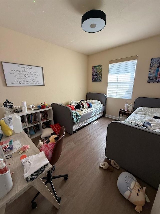 bedroom featuring wood finished floors and baseboards