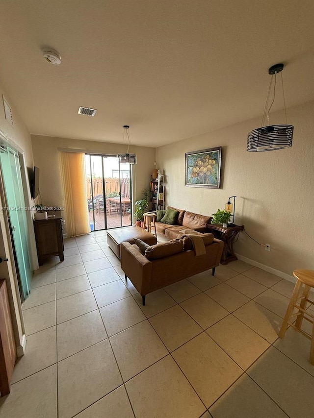 living room featuring light tile patterned floors, baseboards, and visible vents