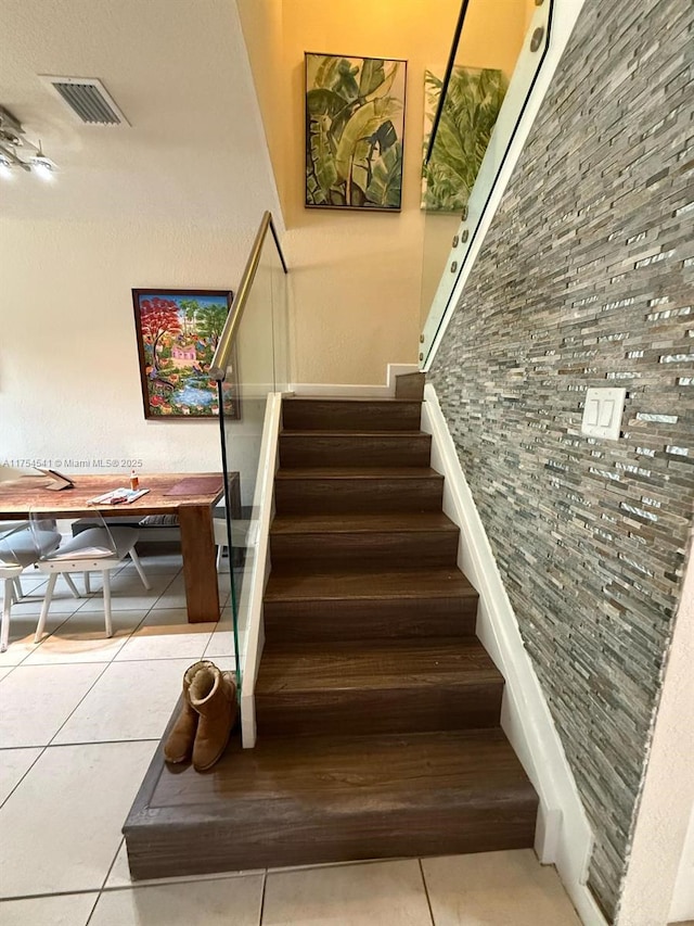 staircase featuring tile patterned flooring and visible vents