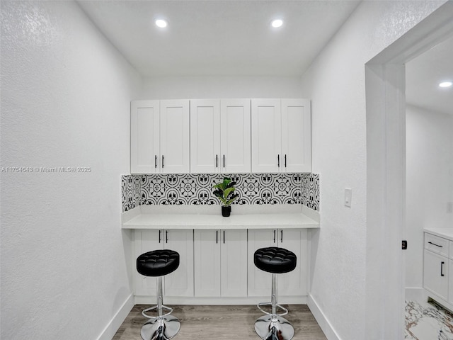 kitchen featuring baseboards, white cabinetry, and a breakfast bar area