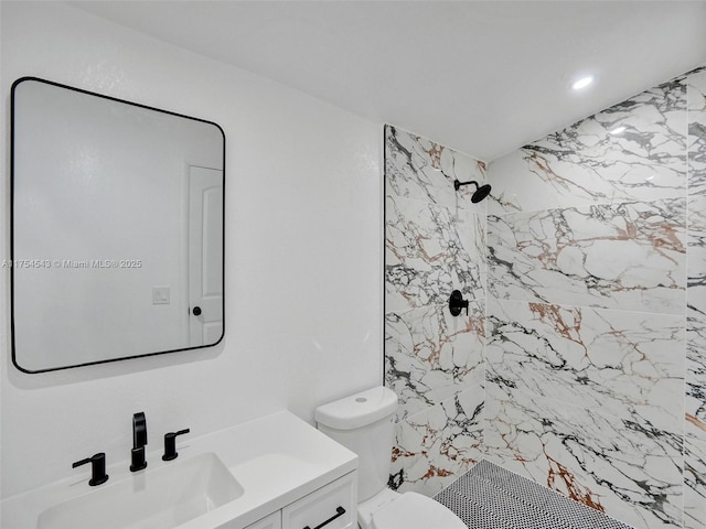 bathroom featuring vanity, a shower stall, and toilet