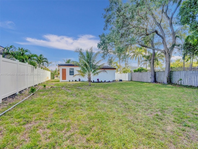 view of yard with an outdoor structure and a fenced backyard