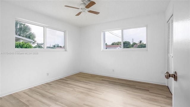 empty room with a ceiling fan and light wood-style flooring