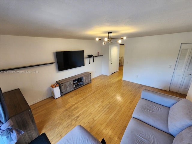 living room featuring light wood-style flooring and a notable chandelier