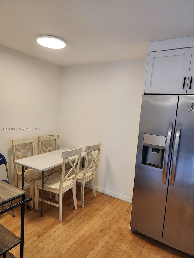 dining room with light wood-type flooring and baseboards