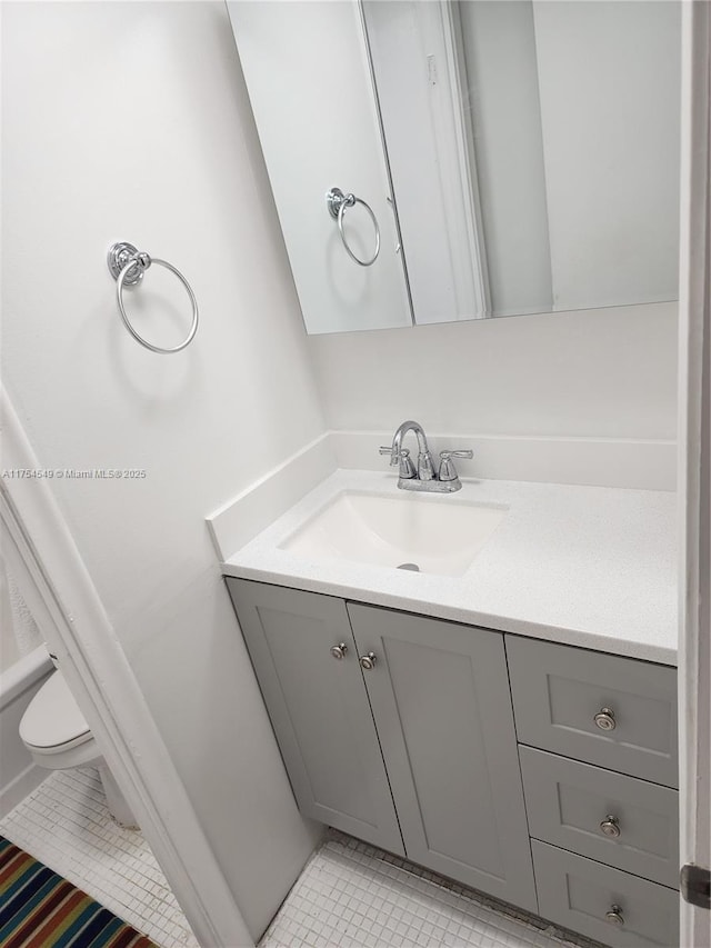 bathroom featuring toilet, tile patterned flooring, and vanity