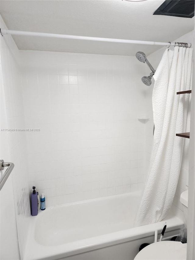 full bathroom featuring shower / bath combination with curtain, visible vents, and toilet