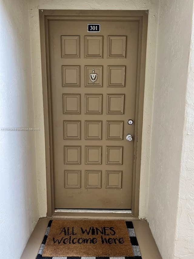 doorway to property featuring stucco siding