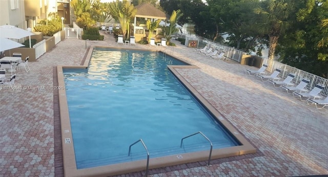 community pool featuring a patio and fence