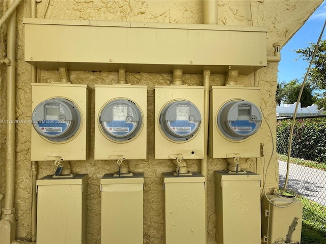 exterior details featuring electric meter and fence