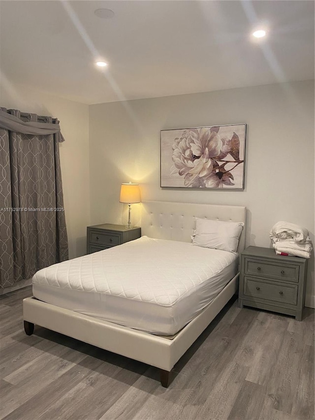 bedroom with wood finished floors and recessed lighting