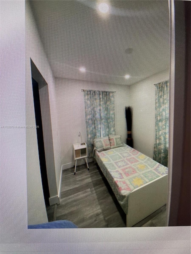 bedroom featuring wood finished floors and baseboards