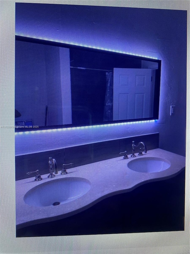 full bathroom featuring double vanity and a sink