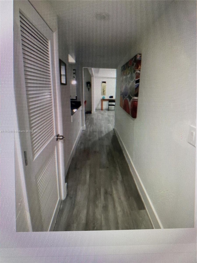 hallway with baseboards and wood finished floors