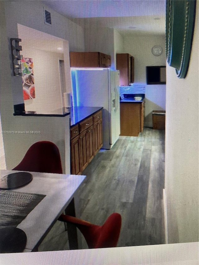 kitchen with brown cabinetry and wood finished floors