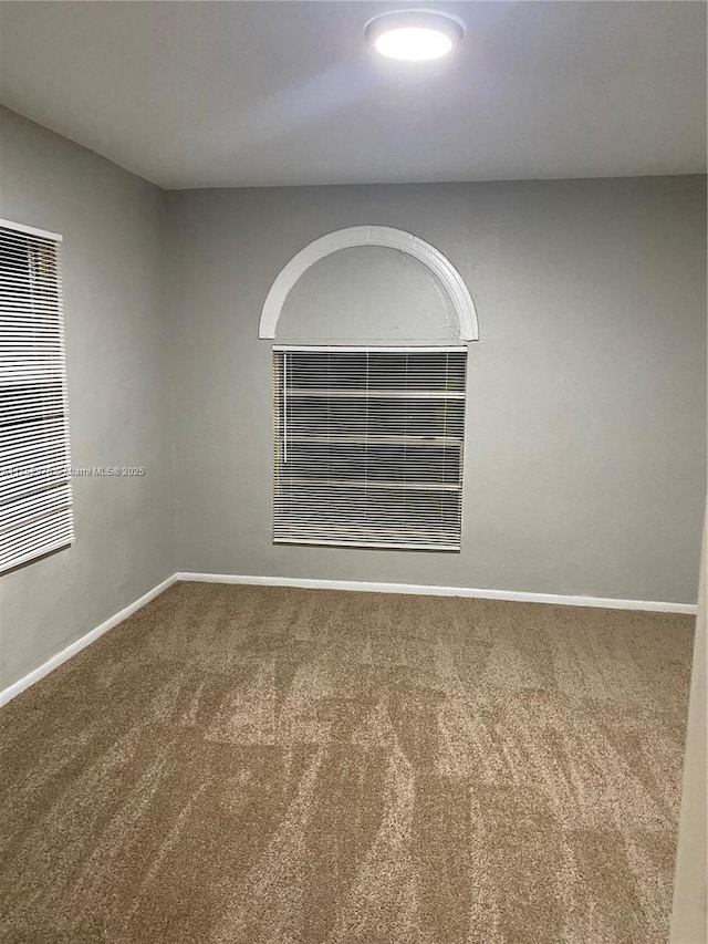 carpeted empty room with baseboards