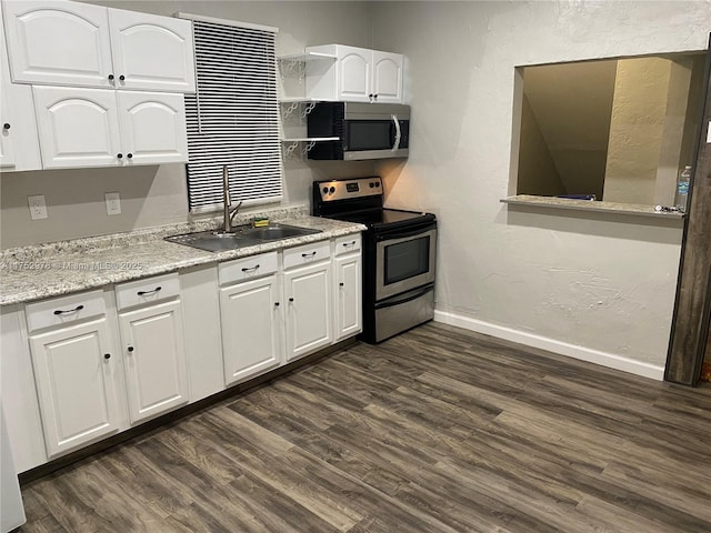 kitchen featuring stainless steel appliances, a sink, white cabinets, baseboards, and dark wood-style floors