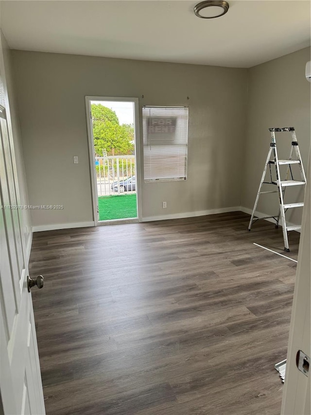 empty room featuring dark wood-style flooring and baseboards