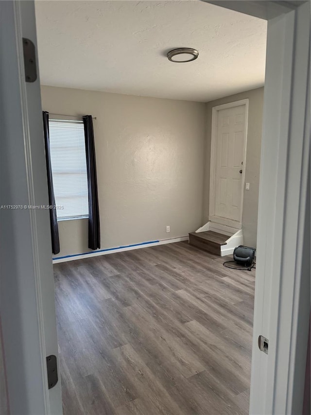 empty room featuring baseboards and wood finished floors