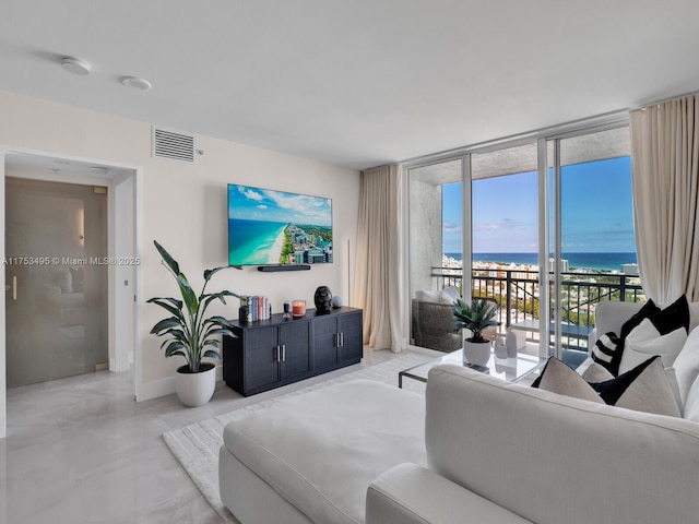 living room with floor to ceiling windows, visible vents, and baseboards