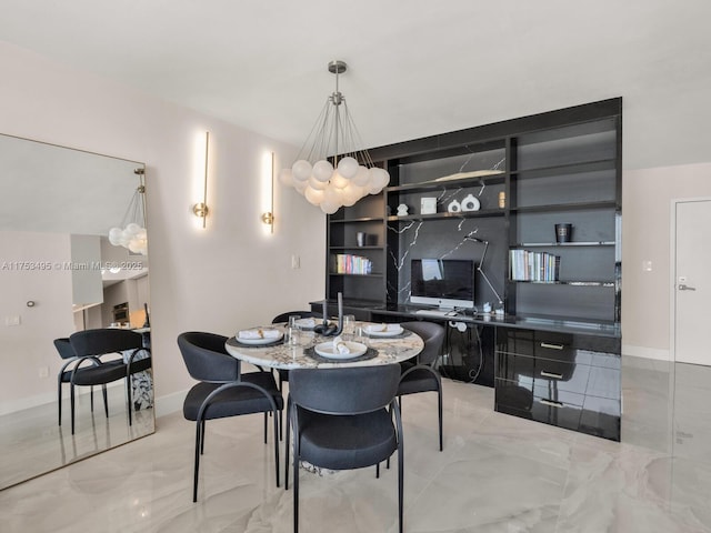 dining space featuring built in features, marble finish floor, and baseboards