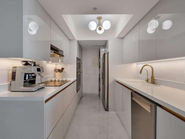 kitchen featuring appliances with stainless steel finishes, white cabinets, a sink, modern cabinets, and wall chimney exhaust hood