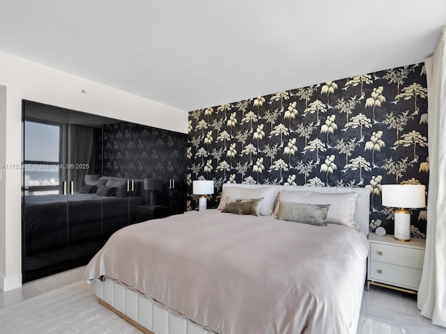 bedroom featuring an accent wall and wallpapered walls